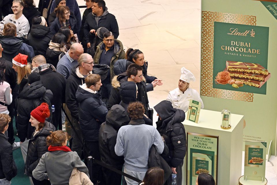 Menschen stehen Schlange vor Stand mit Dubai-Schokoldade