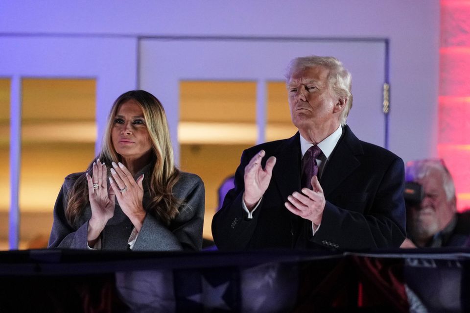 Donald Trump (re.) und Melania Trump (li.) klatschen während eines Feuerwerks im Trump National Golf Club