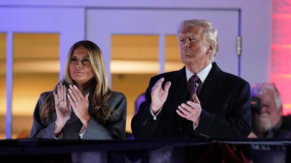 Donald Trump (re.) und Melania Trump (li.) klatschen während eines Feuerwerks im Trump National Golf Club Donald Trump (re.) und Melania Trump (li.) klatschen während eines Feuerwerks im Trump National Golf Club