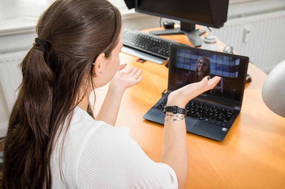 Eine junge Frau spricht bei einem Online-Bewerbungsgespräch mit einer anderen Frau im Laptop
