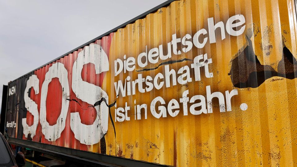 Auf einem Container steht "SOS - Die deutsche Wirtschaft ist in Gefahr."