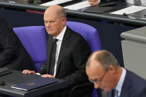 Bundeskanzler Olaf Scholz schaut grimmig auf seinen Herausforderer Friedrich Merz (CDU)