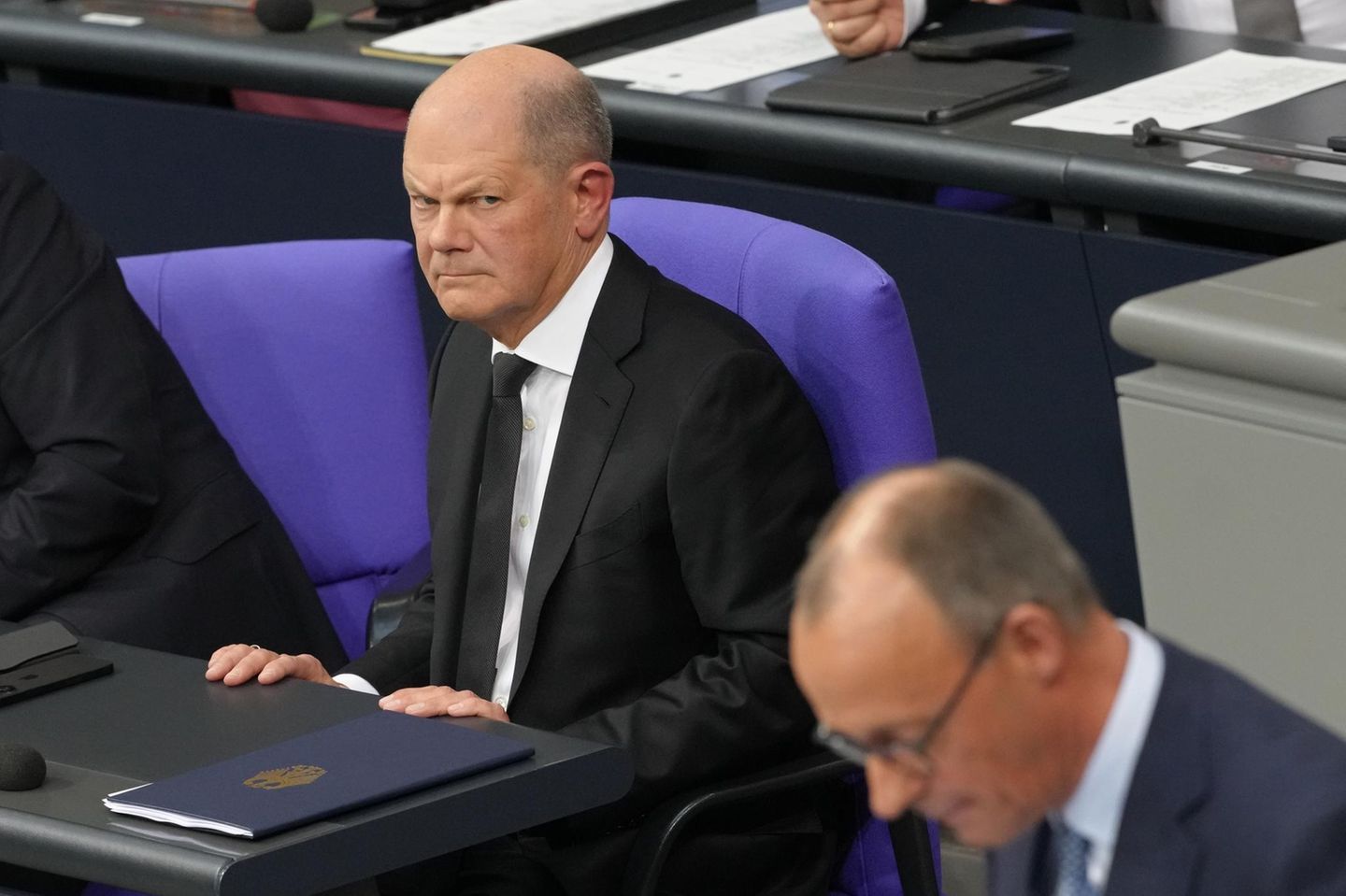 Bundeskanzler Olaf Scholz schaut grimmig auf seinen Herausforderer Friedrich Merz (CDU)