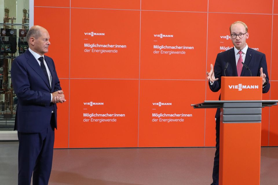 Viessmann CEO Max Viessmann steht rechts an einem Pult und spricht während Olaf Scholz links daneben steht