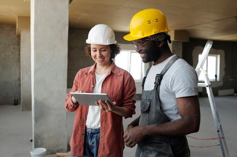 Ingenieurin, die mit einem Kollegen über ein Tablet diskutiert