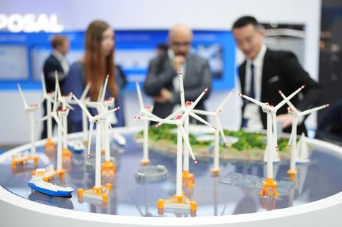 Messebesucher stehen an einem Stand des chinesischen Windturbinen-Herstellers Mingyang
