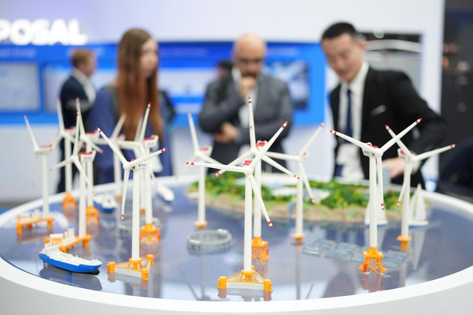 Messebesucher stehen an einem Stand des chinesischen Windturbinen-Herstellers Mingyang