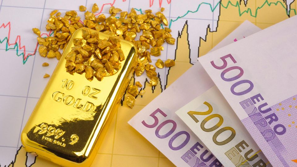 Auf dem Chart einer Börse liegen ein Goldbarren, Goldnuggets und Geldscheine