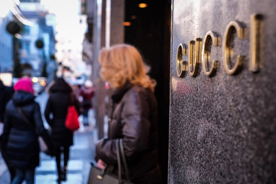 Eine Frau steht vor einem Gucci-Geschäft in Mailand