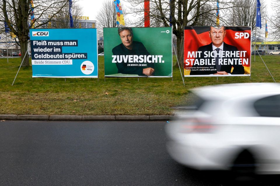 Wahlplakate von CDU, Grüne und SPD stehen auf einer Wiese