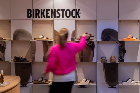 Verschiedene Schuhe von Birkenstock stehen in Regalen in einer Filiale