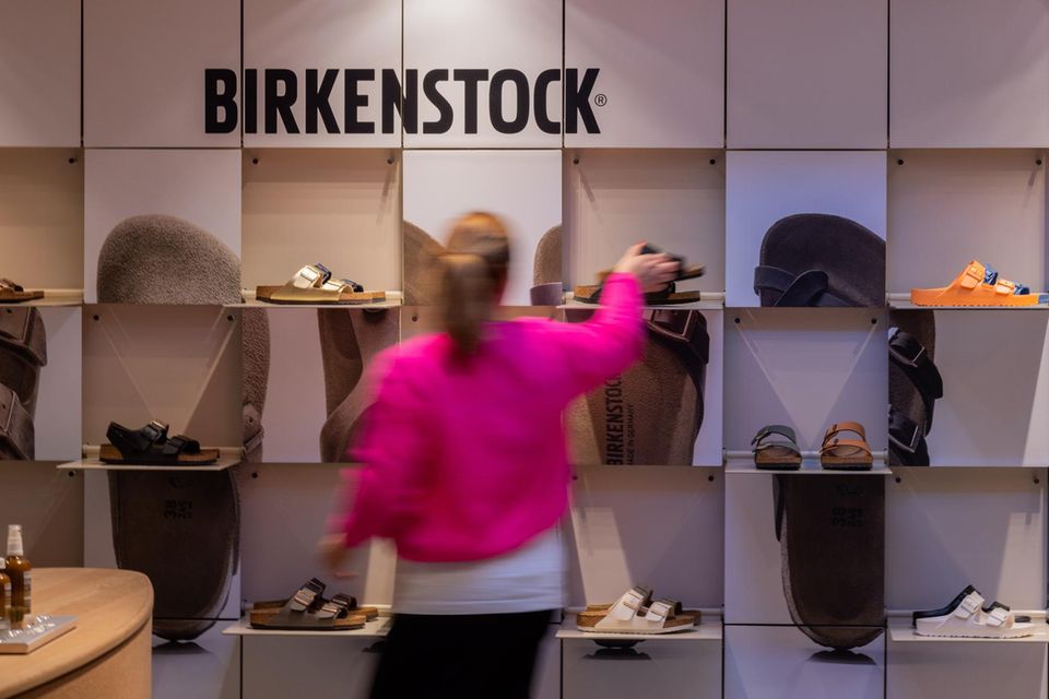 Verschiedene Schuhe von Birkenstock stehen in Regalen in einer Filiale