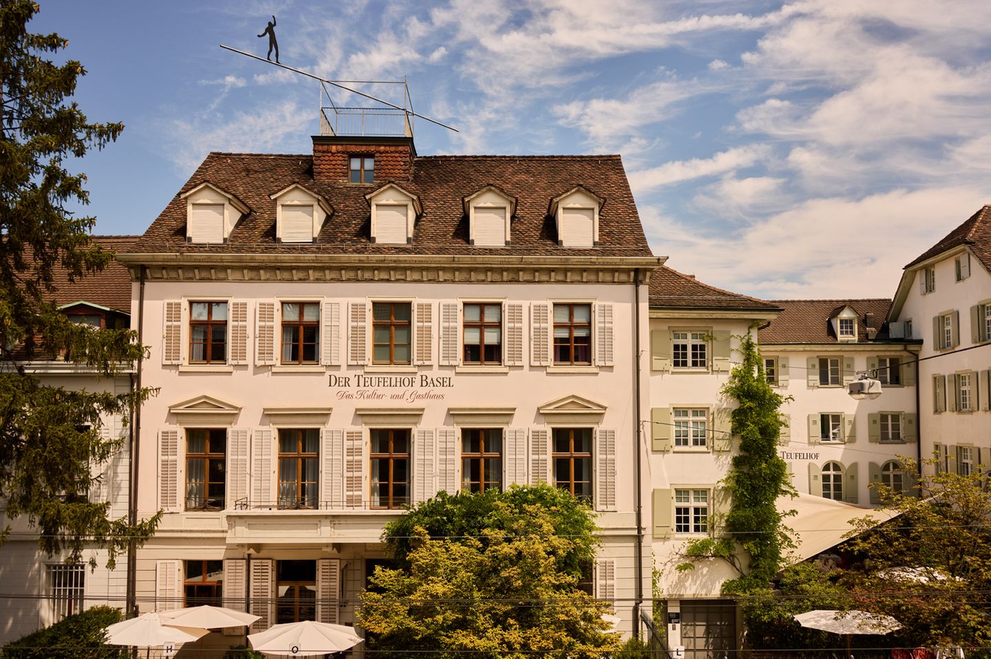 Die kunstvolle Fassade des Hotels „Teufelhof Basel“ mit dem berühmten Seiltänzer auf dem Dachfirst   