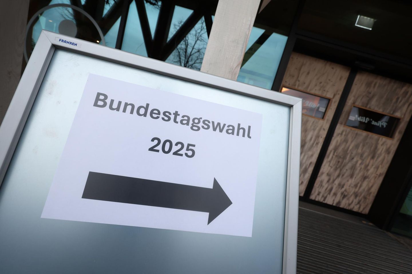 Ein Hinweisschild mit der Aufschrift "Bundestagswahl 2025" steht vor einem Wahllokal