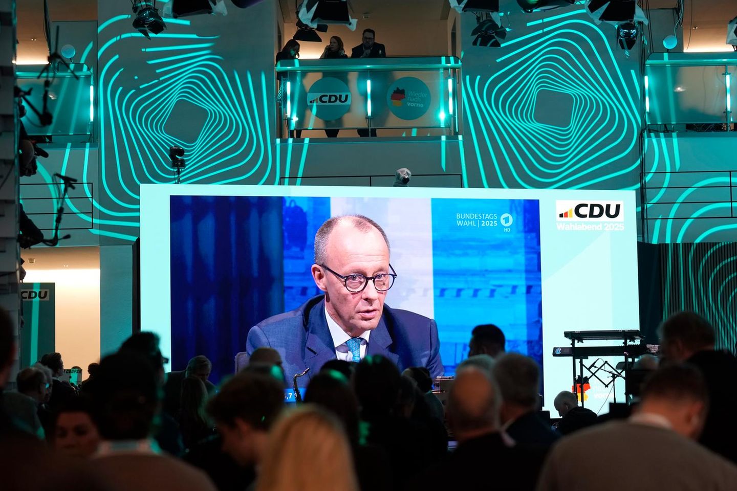 Friedrich Merz ist am Wahlabend in der CDU-Zentrale auf einem großen Bildschirm zu sehen