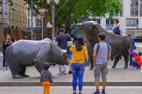 Menschen neben den Bulle und Bär Statuen an der Börse Frankfurt