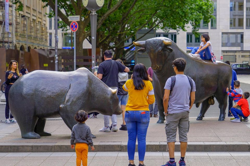 Menschen neben den Bulle und Bär Statuen an der Börse Frankfurt