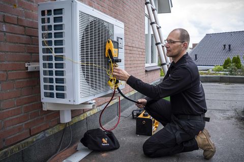Ein Handwerker installiert eine Wärmepumpe
