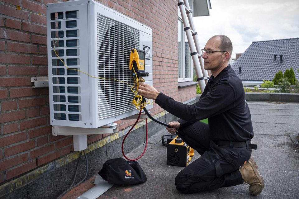 Ein Handwerker installiert eine Wärmepumpe