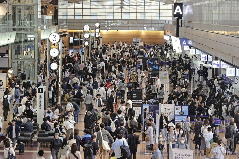 Menschen drängen sich am Flughafen Haneda von Tokio