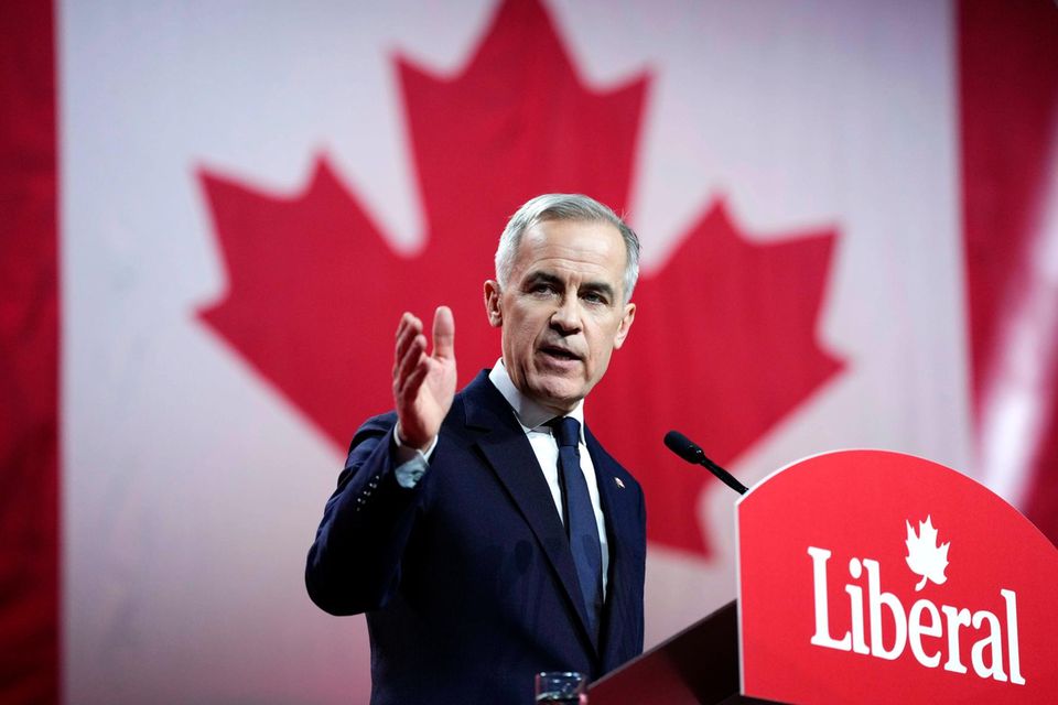 Mark Carney, Kanads neuer Premier steht an einem Pult vor einer Flagge Kanadas
