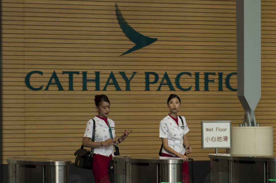 Mitarbeiter von Cathay Pacific Airways beim Verlassen des Unternehmenssitzes in Hongkong, China