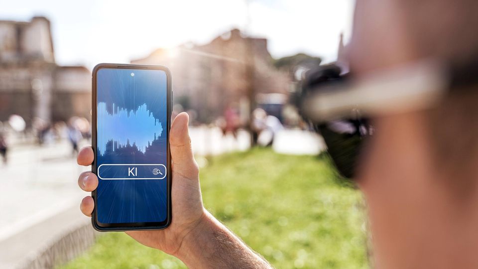 Ein Mann hält ein Smartphone, das den Einsatz von KI symbolisiert Ein Mann hält ein Smartphone, das den Einsatz von KI symbolisiert