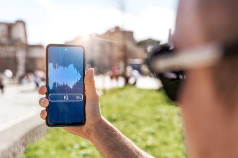 Ein Mann hält ein Smartphone, das den Einsatz von KI symbolisiert