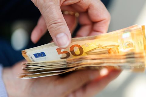Ein Mensch zählt 50-Euro-Scheine