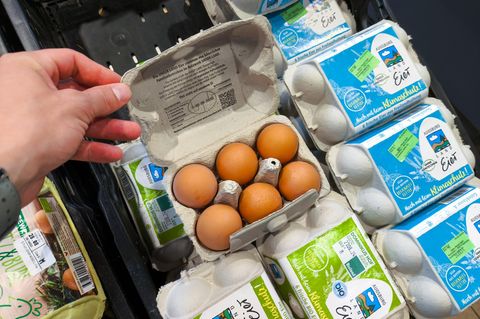 Ein Kunde öffnet einen Eierkarton im Supermarkt