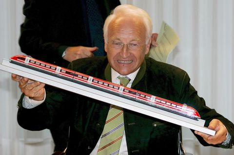 Edmund Stoiber hält ein Transrapid-Modell in den Händen