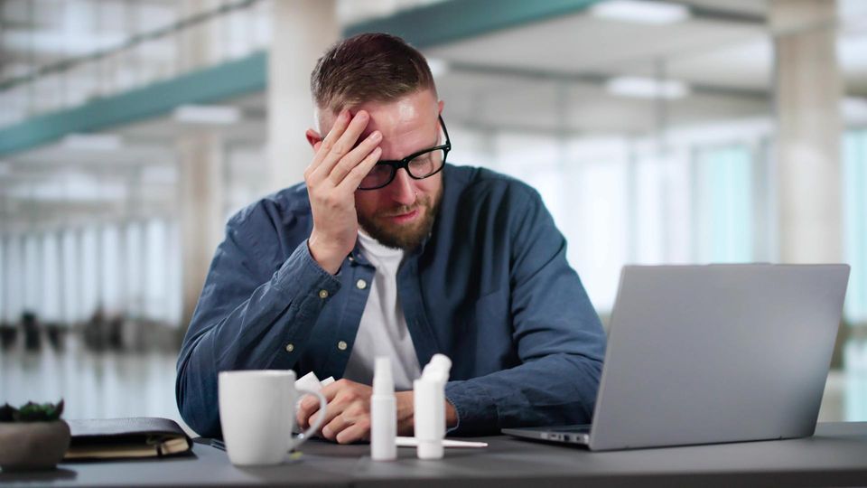 Kranker Büroangestellter bei der Arbeit