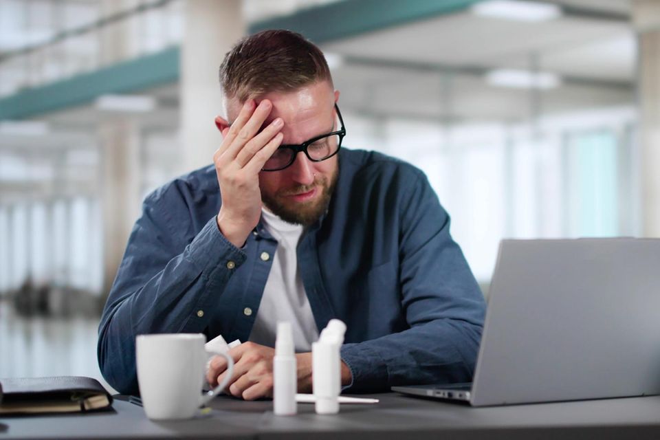 Kranker Büroangestellter bei der Arbeit