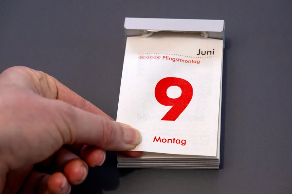 Frau reisst das Kalenderblatt ab