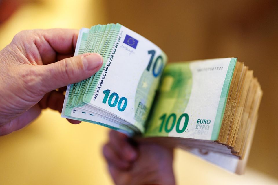 A woman counts euro banknotes