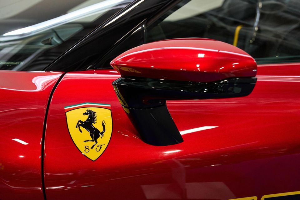 in Ferrari SF90 XX Stradale mit Ferrari Logo vor dem Spiegel