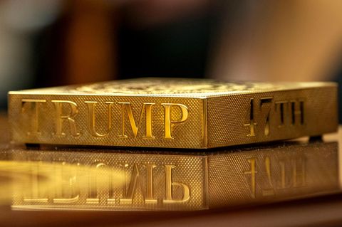 Ein goldener Getränkeuntersetzer mit Trumps eingraviertem Namen liegt auf dem Couchtisch im Oval Office