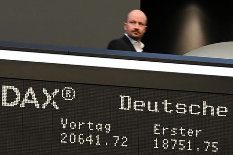 Während ein Besucher auf der Empore der Frankfurter Börse steht, zeigt die Anzeigetafel einen starken Verlust an