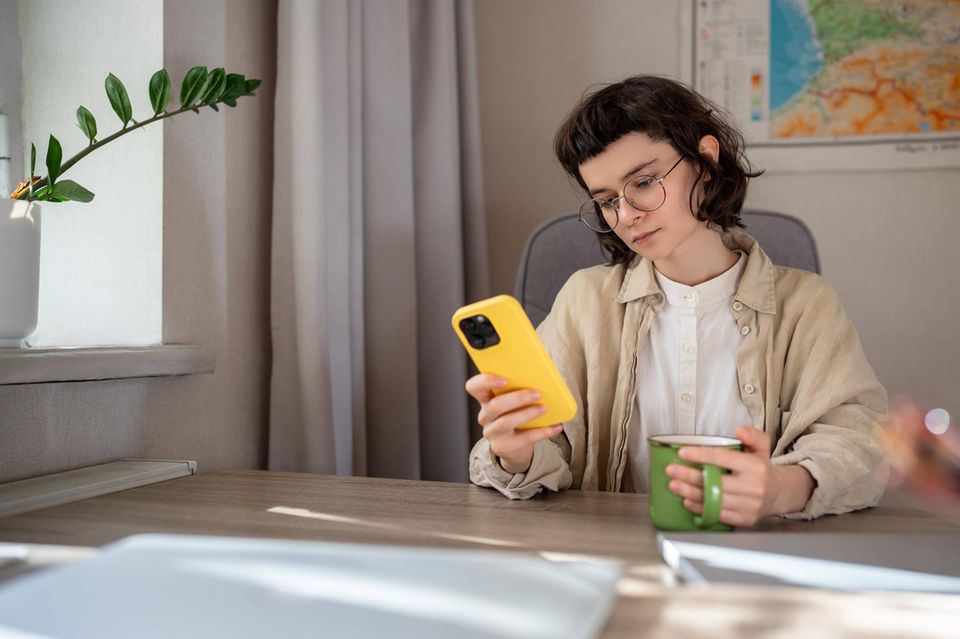 Junge Person sitzt zu Hause und scrollt durch diverse Apps