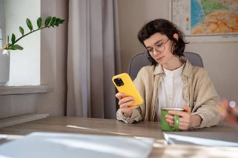 Junge Person sitzt zu Hause und scrollt durch diverse Apps
