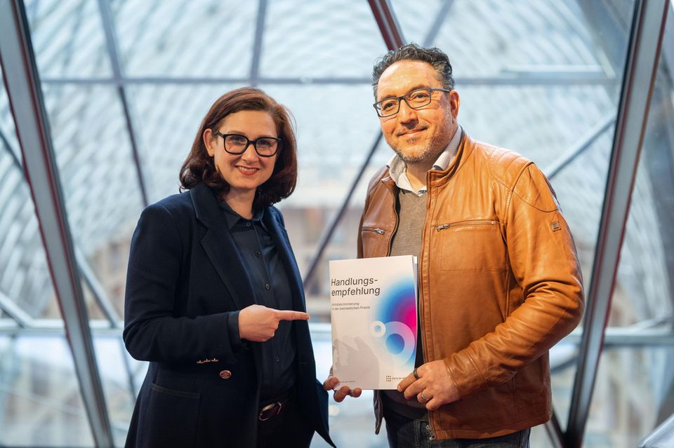 Ferda Ataman und Cawa Younosi halten eine Broschüre der Charta der Vielfalt
