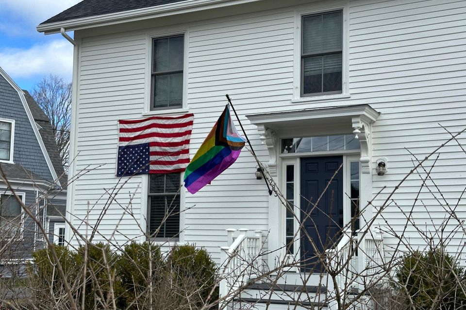 An einem Haus in Maine hängen eine Pride-Flagge für Vielfalt und eine umgedrehte USA-Flagge