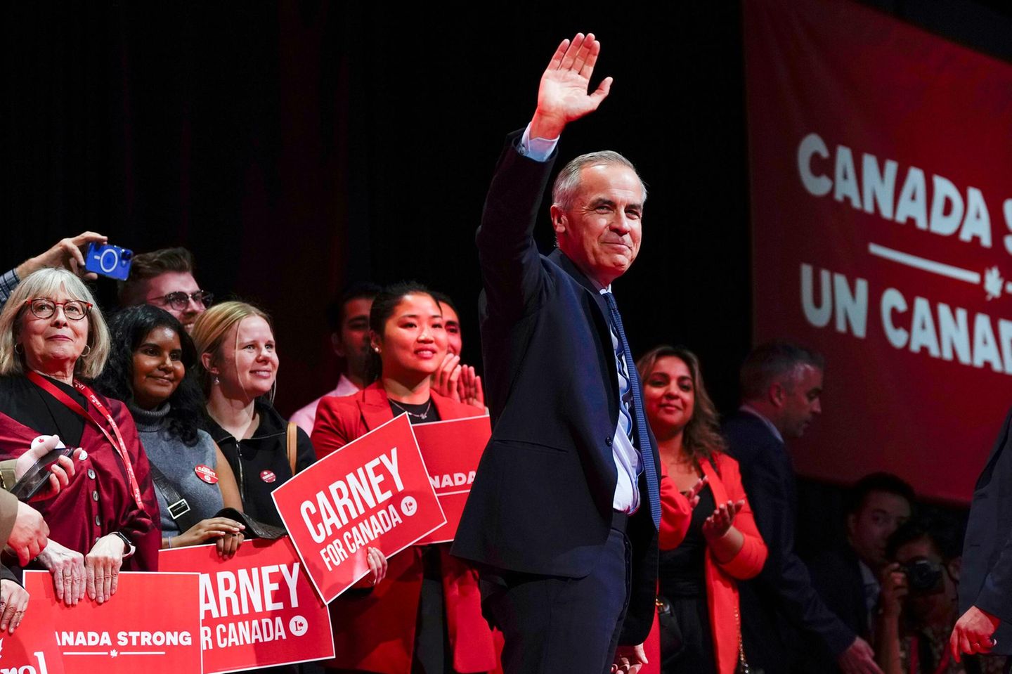 Mark Carney, Kanads neuer Premier steht an einem Pult vor einer Flagge Kanadas