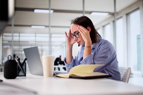 Eine Frau sitzt im Büro vor einem Notebook