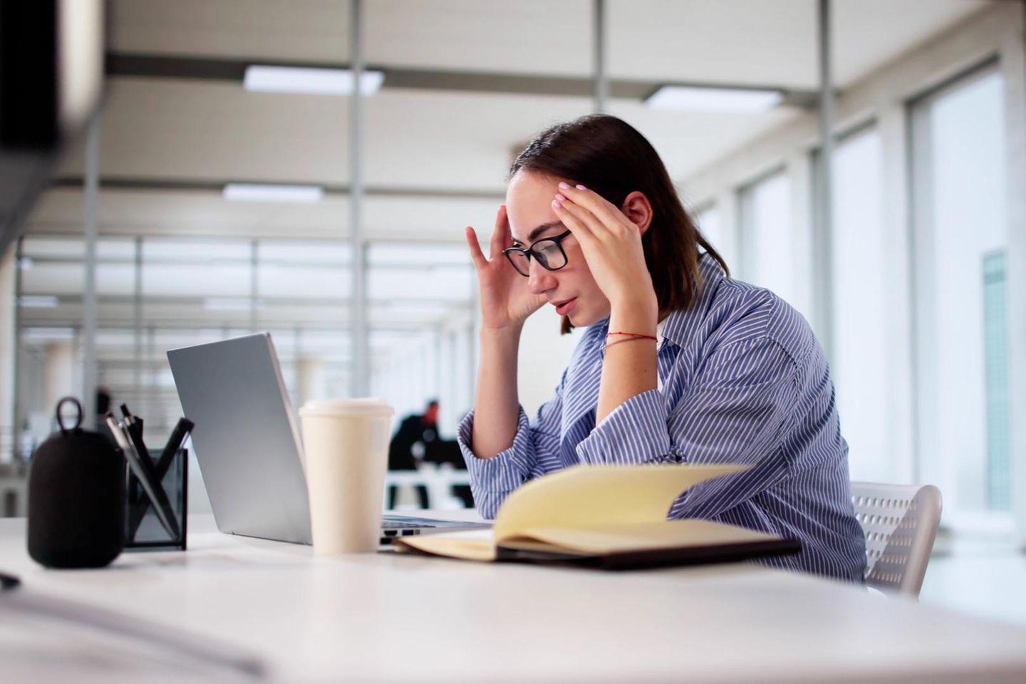 Eine Frau sitzt im Büro vor einem Notebook