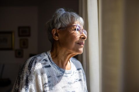 Alte Frau schaut aus dem Fenster