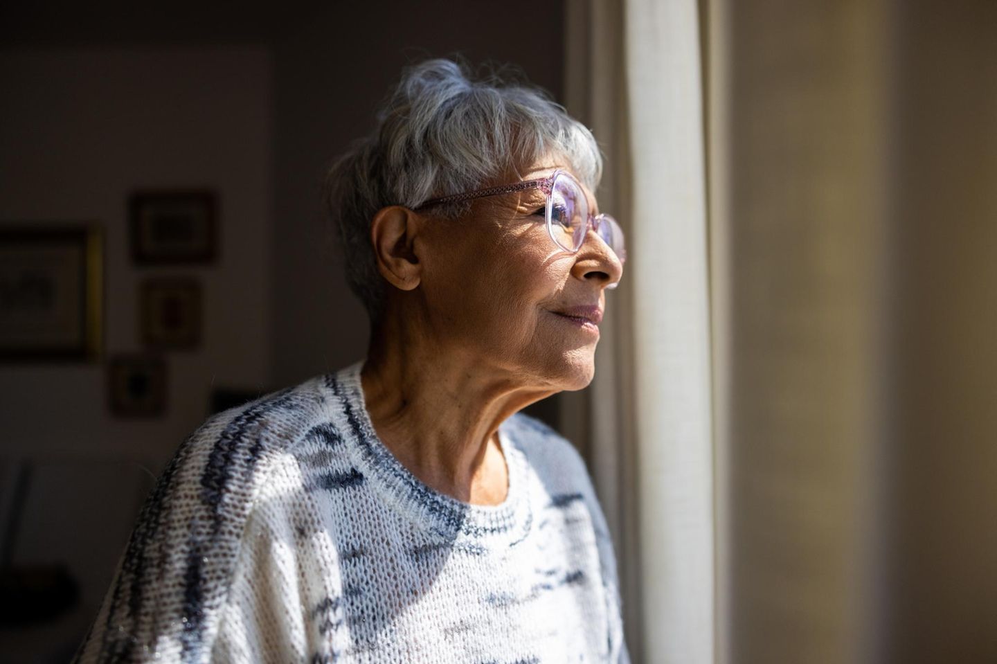 Alte Frau schaut aus dem Fenster