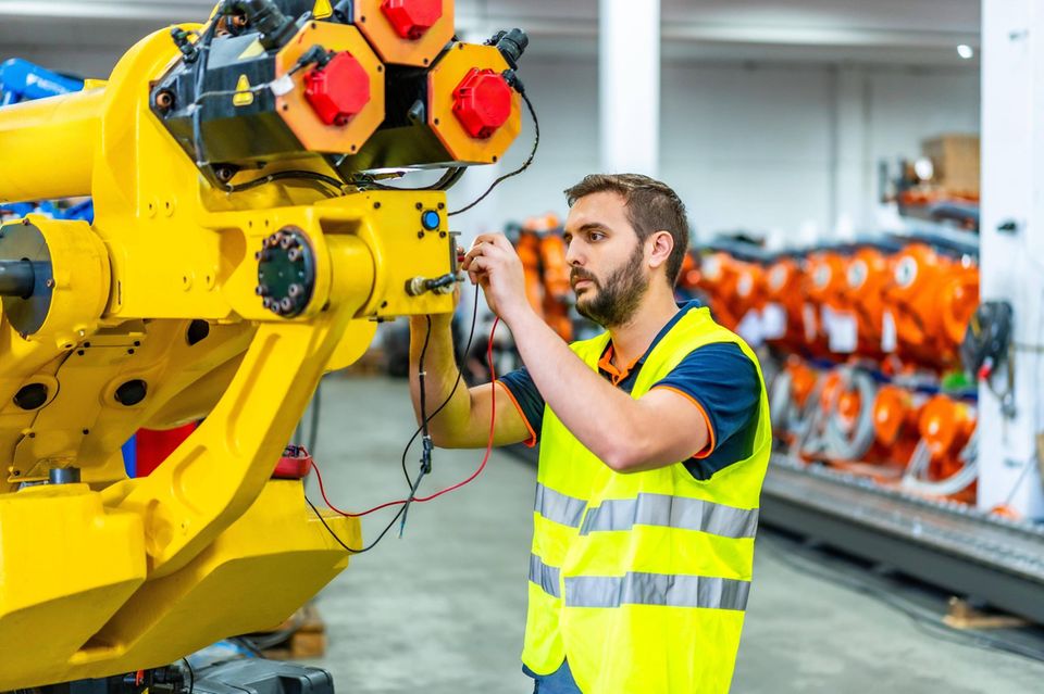 Maschinenbauingenieur bei der Inspektion und Befestigung eines mechanischen Arms