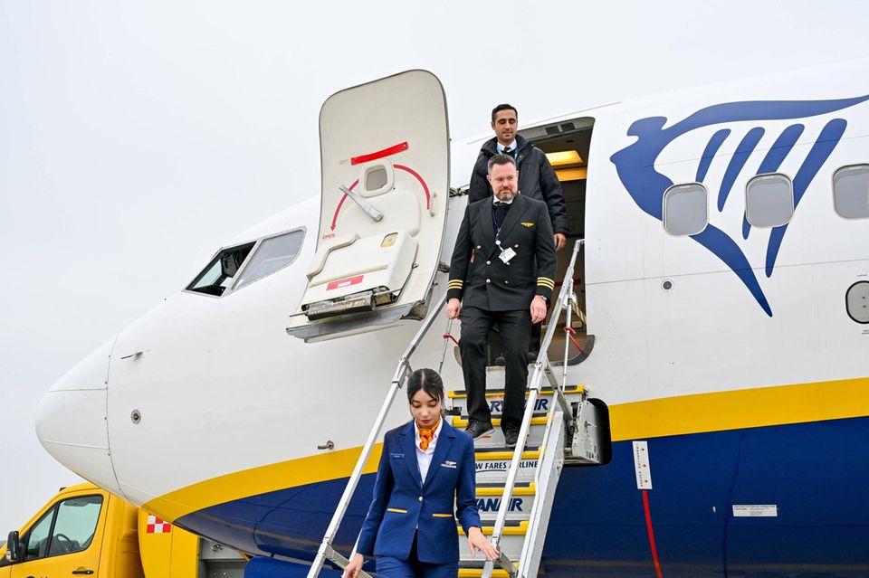 Flugkapitän und Flugpersonal steigen aus einem Flugzeug ab