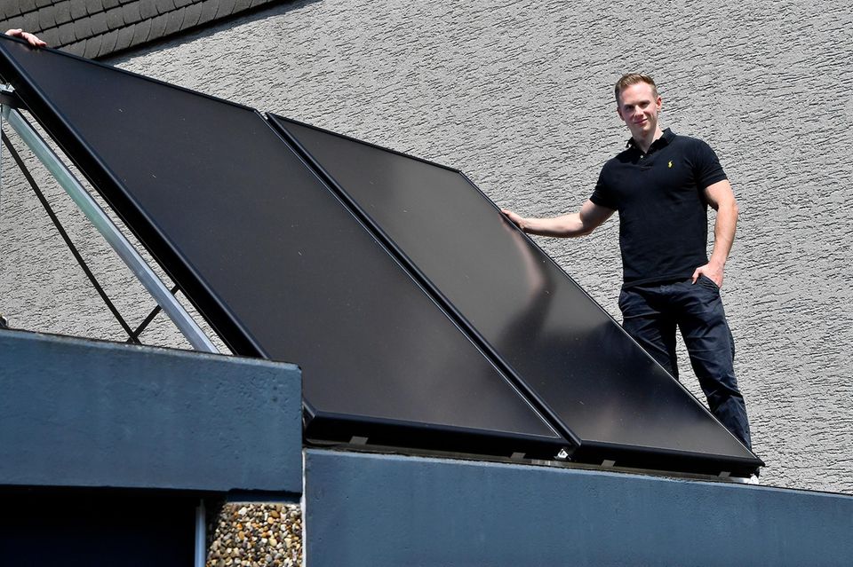 Dipl.-Ing für Gebäudeausrüstung und Energieberater steht neben einer Photovoltaik-Anlage